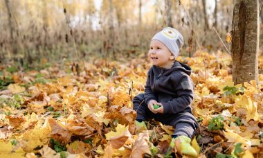 dziecko bawi się w lesie jesienią