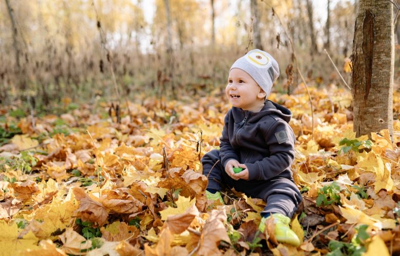 dziecko bawi się w lesie jesienią